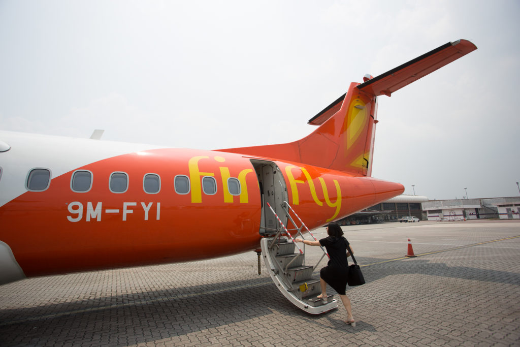 Tail of Firefly's ATR-72-500 with a women walking up to board