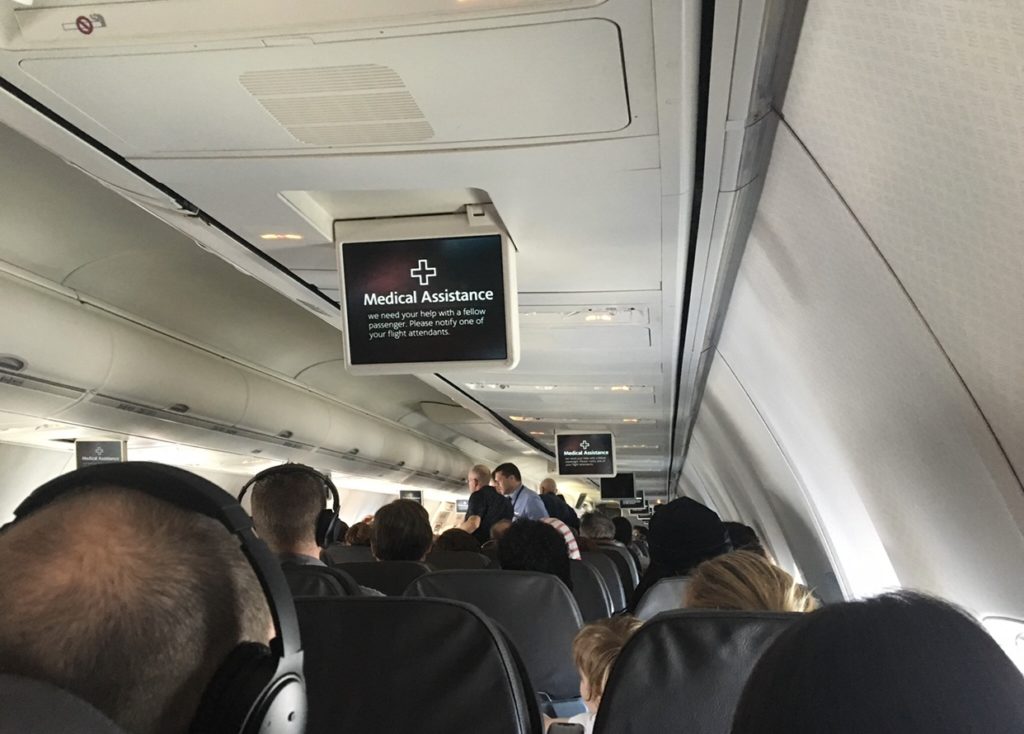 An American Airlines overhead screen, which alerts passengers that the crew needs "Medical Assistance" for a passenger on board