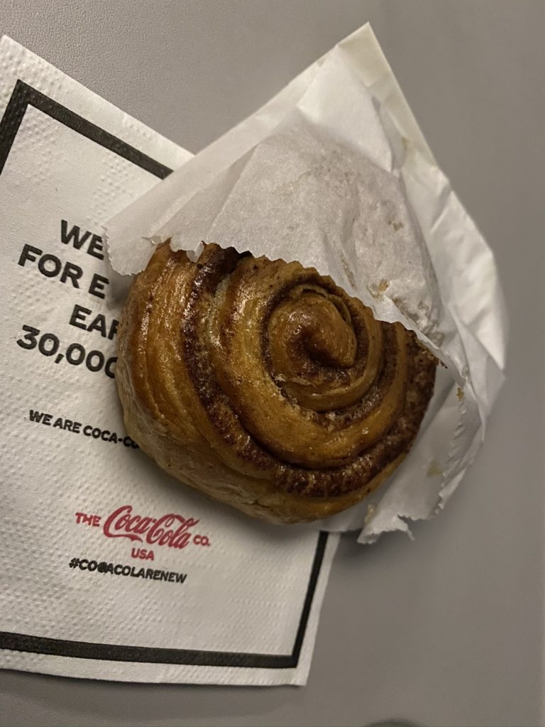 Cinnamon roll in a bag on aircraft tray table