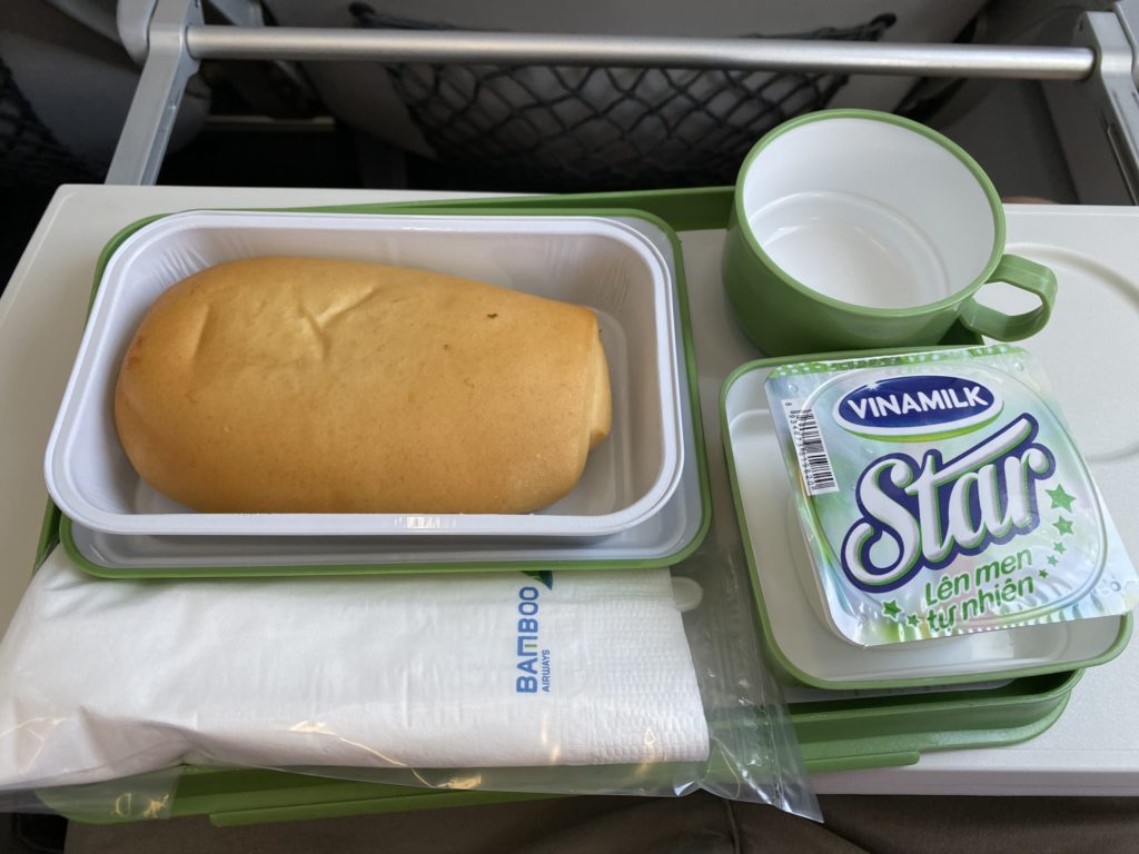 Meal on Bamboo Airways with sandwich, yogurt and drink on tray table