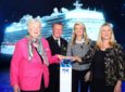 poppy with two other women and a man standing at a podium with a cruise ship in the backdrop