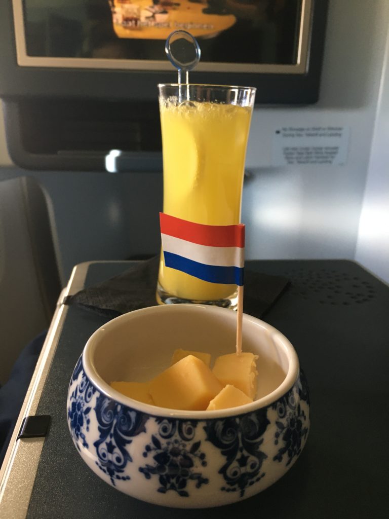 drink and cheese displayed on aircraft table