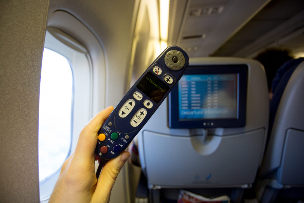 Remote that controls IFE being held up on aircraft