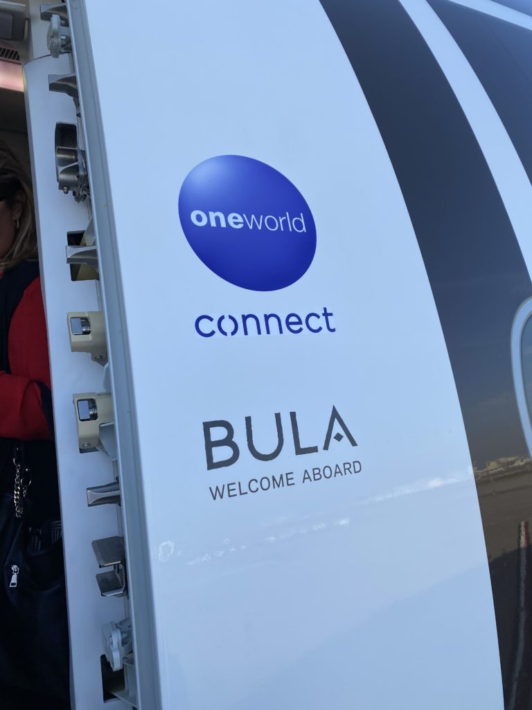 Fiji Airways is a member of oneworld, and the oneworld logo shown here greets passengers, as well as the words "BULA welcome aboard"