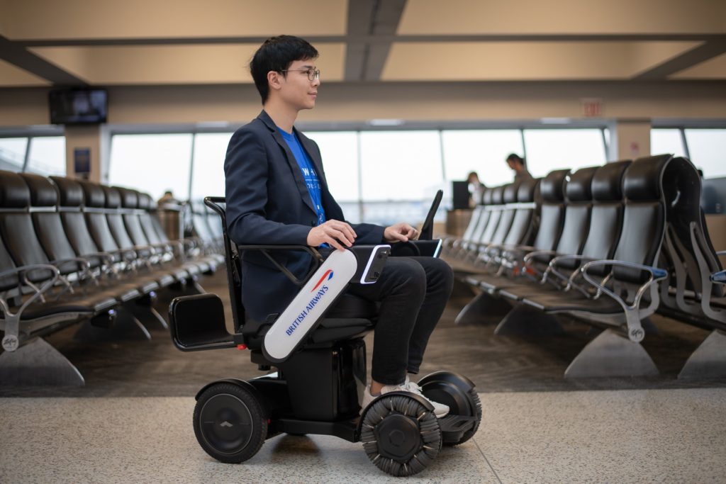 A man using the BA autonomous wheelchair in an airport terminal