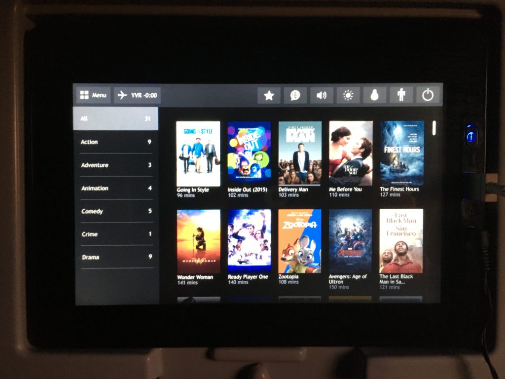 Seatback IFE screen showing a small seletion of movies such as Inside Out, Me Before You, Delivery Man and a few more