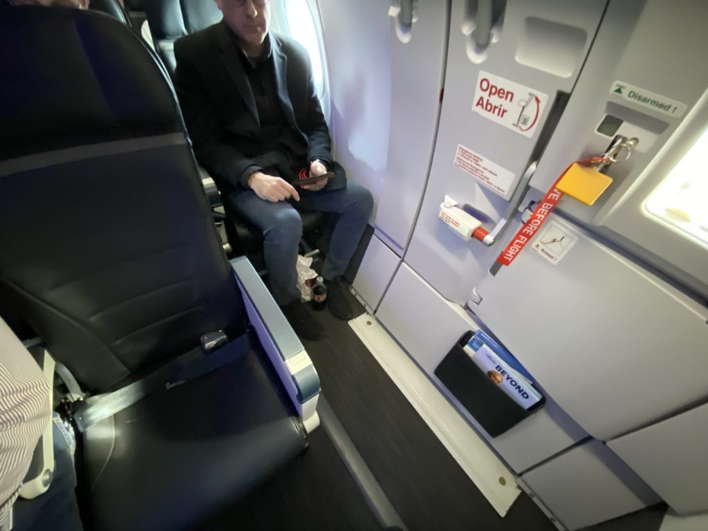 Alaska airlines interior showing exit row seating with a man in the seat behind