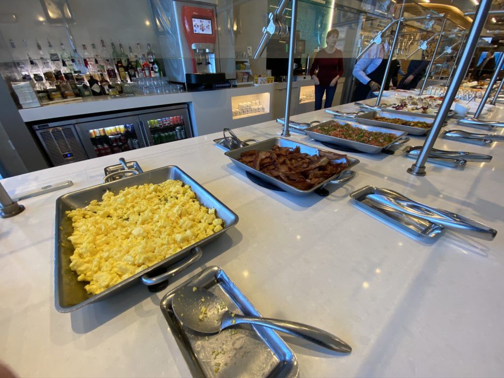 Beakfast buffet displayed showing scrambled eggs, bacon and other staples