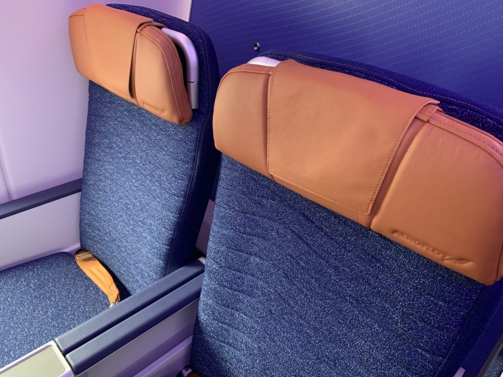 Two Aeroflot economy class seats with a wave-like design on the blue speckled seat covers with bronze headrests