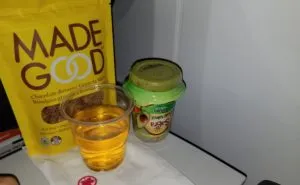 A bag of Made Good snacks on the aircraft tray table. Made Good is a top ten allergen-free food. It is often recognized for its allergen safety.