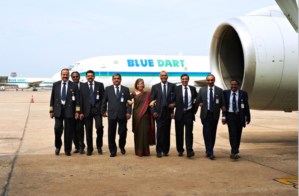 Blue Dart's managing director stands in front of a Blue Dart twinjet, arm-in-arm with the Blue Dart board of directors.