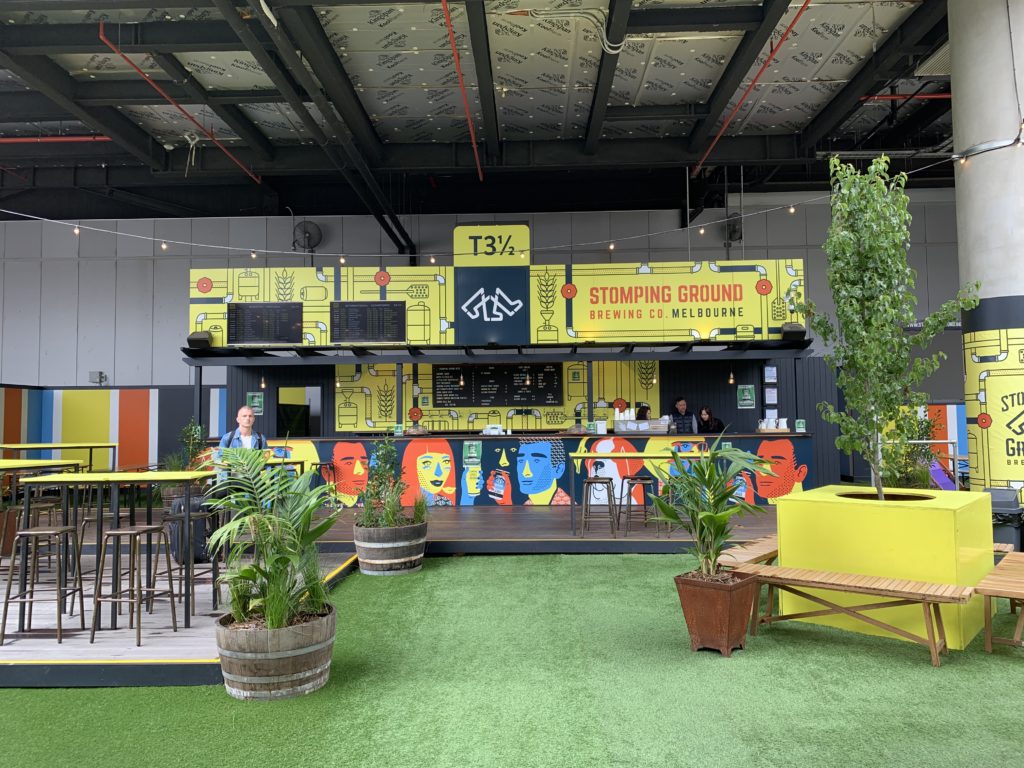 A beer-drinking space with fake green carpet, plants and an outdoor "atmosphere"