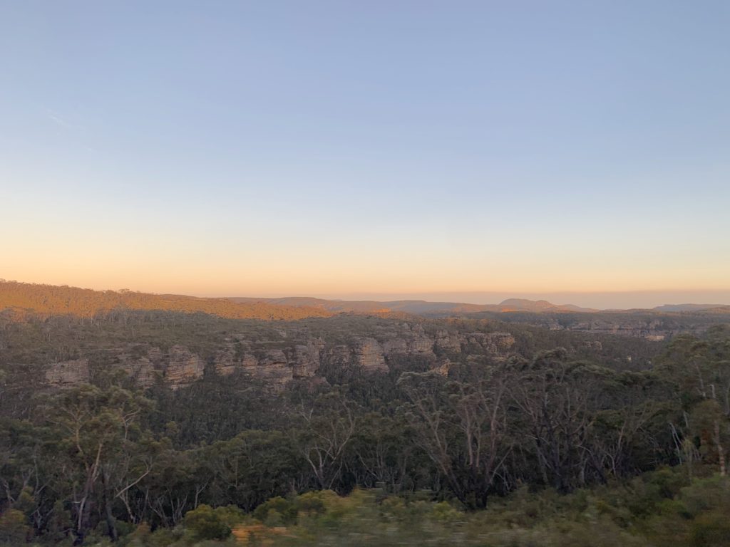 A scenic view of mountains in the background, and a sunset