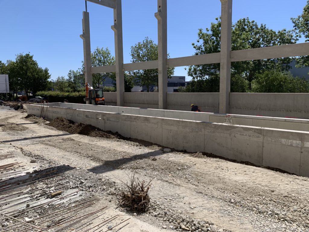 Under construction, the concrete foundational beginnings of Recaro's expansion plan are shown, with a blue sky and green trees in the background