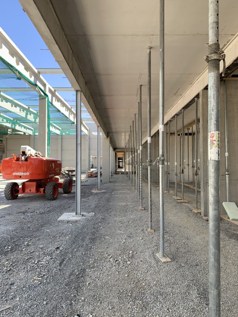 The spine walkway is shown with metal poles in a row, and an orange piece of machinery in view