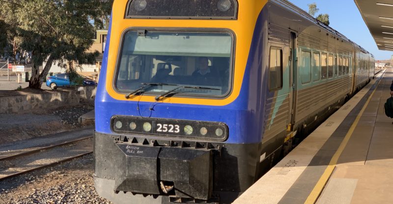 The Outback Xplorer train on the track, pained in blue and yellow