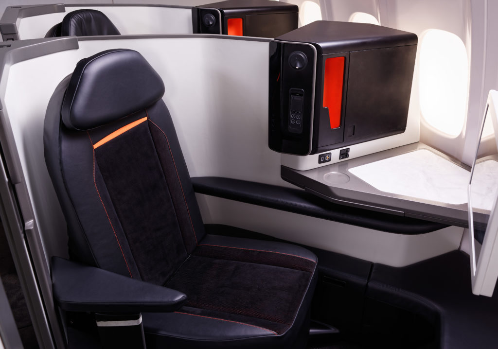 The Opera seat on board an aircraft. The seat is shown in black leather with white and grey thermoplastic shrouding. 