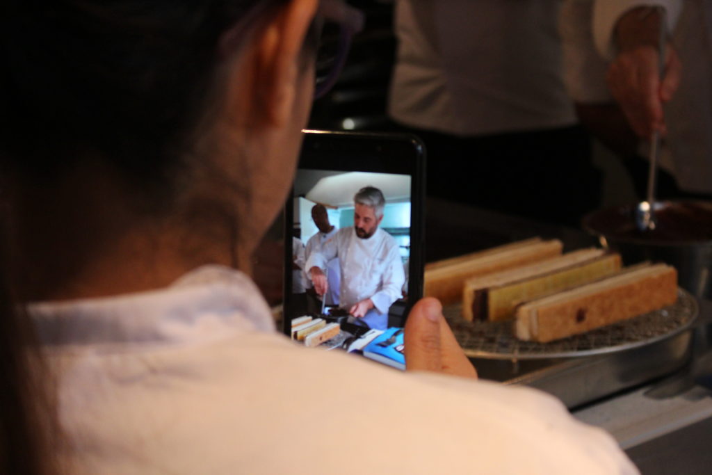 A cooking class is seen on a woman's mobile device.