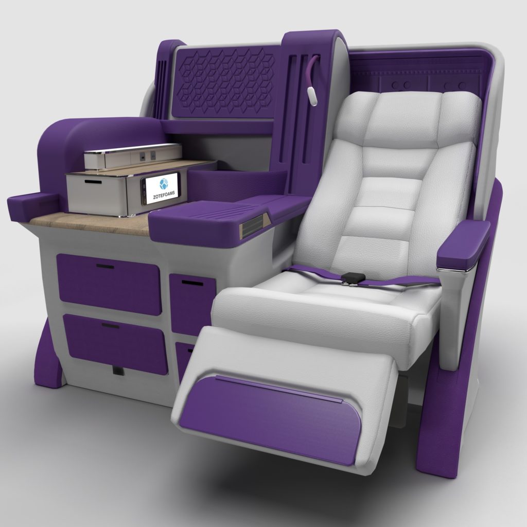 A premium class seat in grey surrounded by various foam structures in purple, including armrest and storage spaces