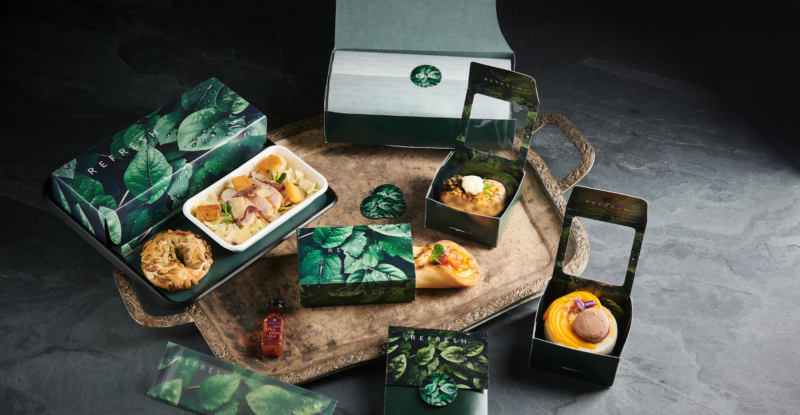 A boxed-up inflight lunch consisting of individually packed salad, sandwich and dessert