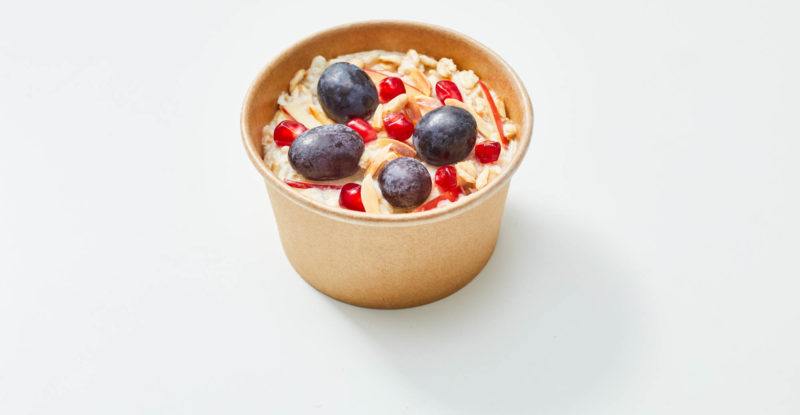 Bircher Muesli displayed in a brown bowl on the center of a white background