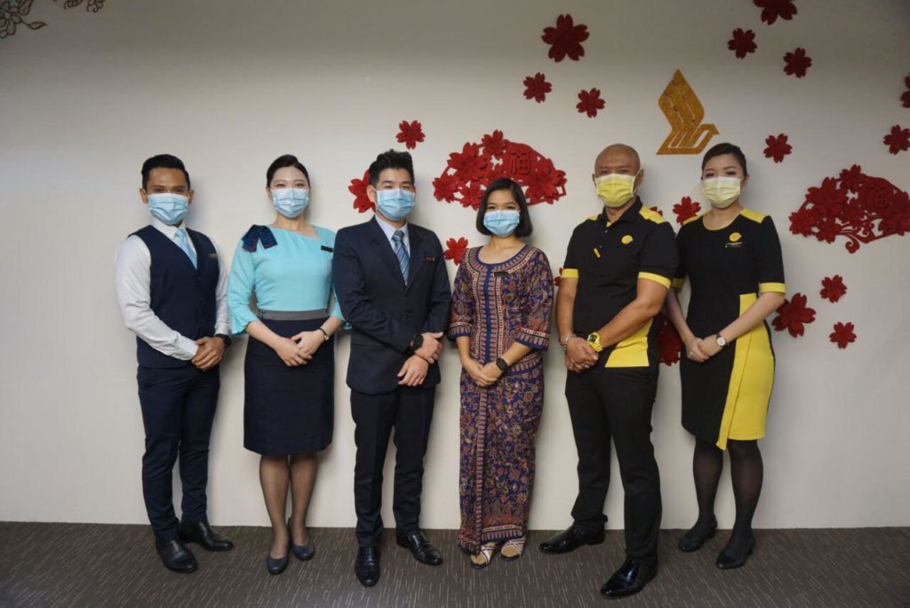 Some of the SIA cabin crew and pilots, in masks, who have received the COVID-19 vaccine