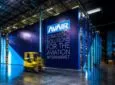 Blu walls built up in a warehouse with a small forklift passing by. One wall says "AVAIR Strategic solutions for the aviation aftermarket."