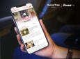 Hand holding mobile device with ikono tv landing page.