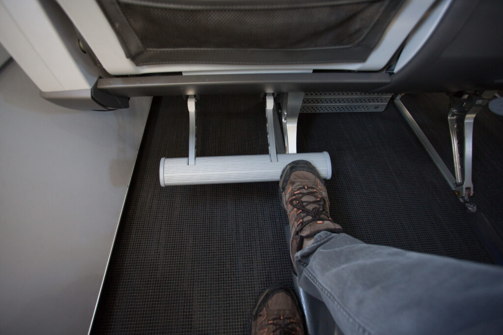 Alaska Airlines' first class seat footrest with a man's foot on it