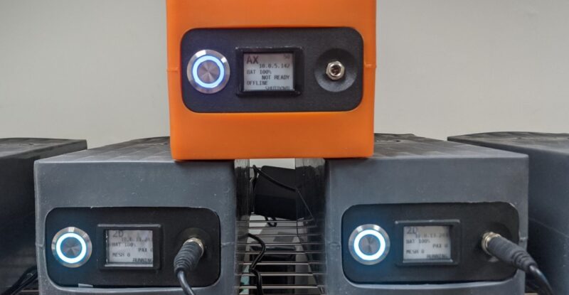 3 AirFi units stacked on top of each other. Two black units on the bottom with an orange unit sitting on top.