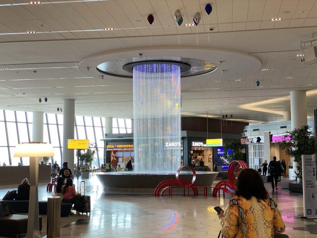 Circular water fall cascading from the ceiling in front of LaGuardia food court.