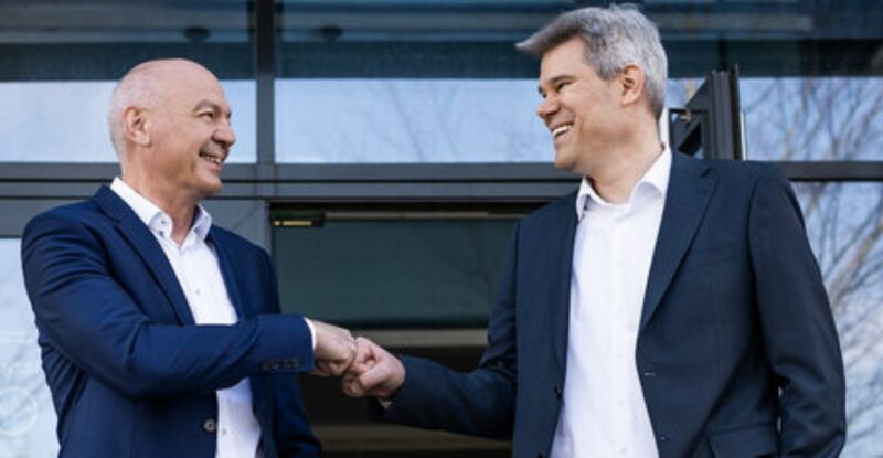 Two men in suits fist bumping in front of a building. Josef Köcher new CEO. image: Diehl Aviation