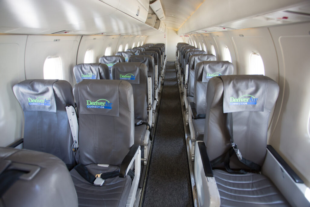 Denver Air Connection Dornier 328JET interior in a 1-2 configuration. Seats are grey and walls are white.