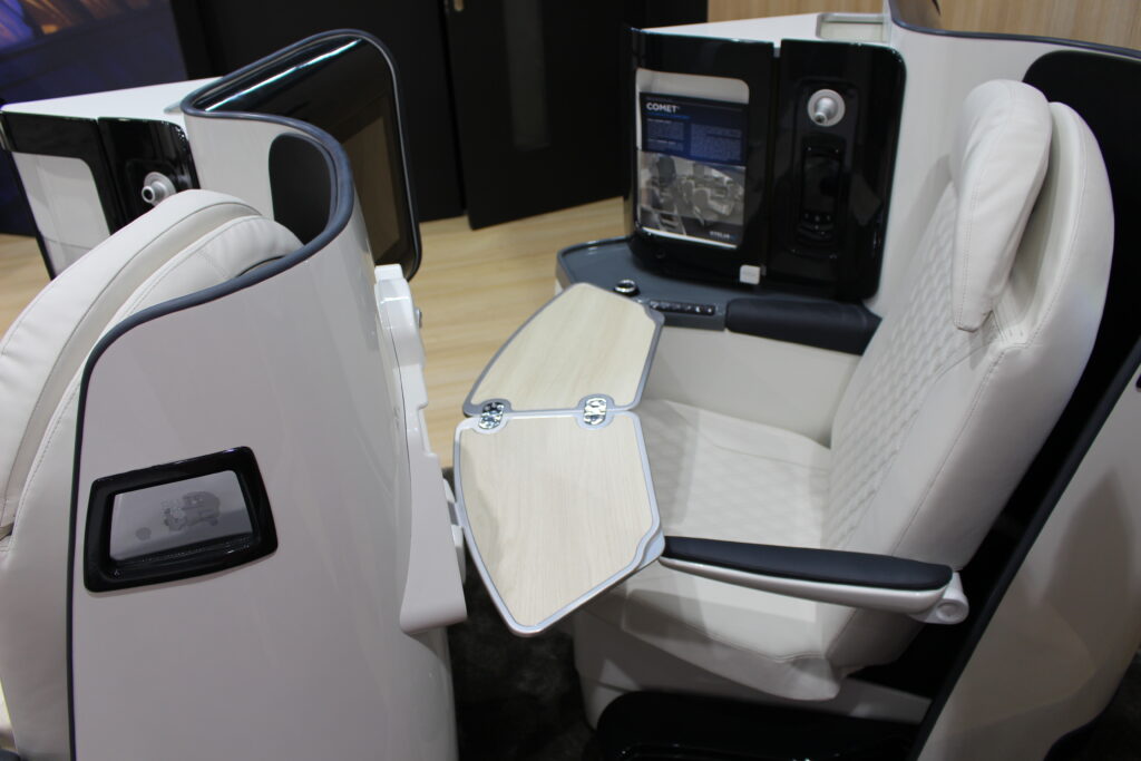 Aircraft herringbone business class seat, Comet, is shown in grey with black trim on the show floor.