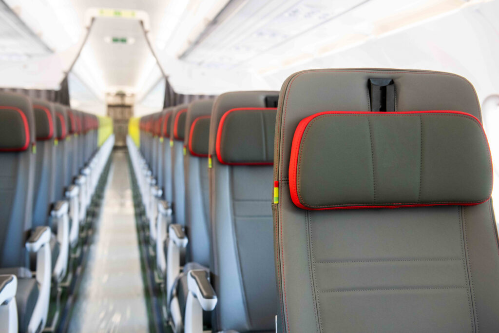 Tap Airlines' Airbus hybrid configuration with Recaro seats. The seats at the forefront are grey with red trim on the headrest. They are more fully featured than the slimlines down back