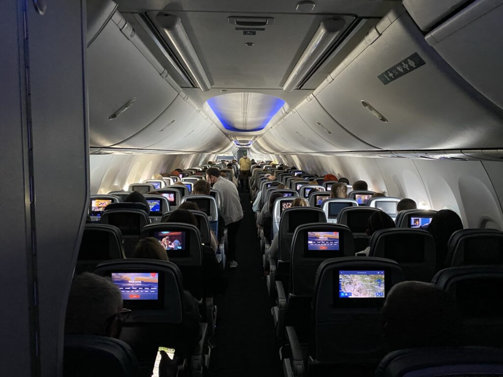 Long view of the Delta 737-900ER cabin with large overhead bins.