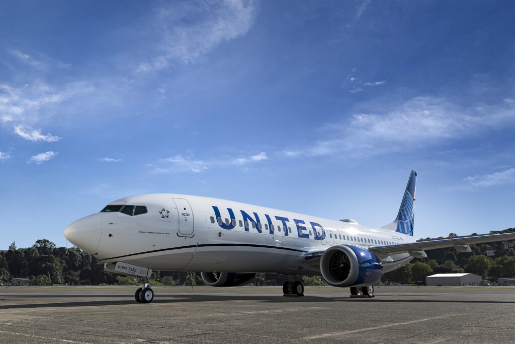 United's Boeing 737 MAX 8, parked, in the carrier's livery, with a blue sky as background