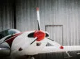 Close up of white and red small aircraft out of the hangar.