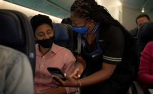 United flight attendant showing a passenger how to use pre-order for snacks. Cares