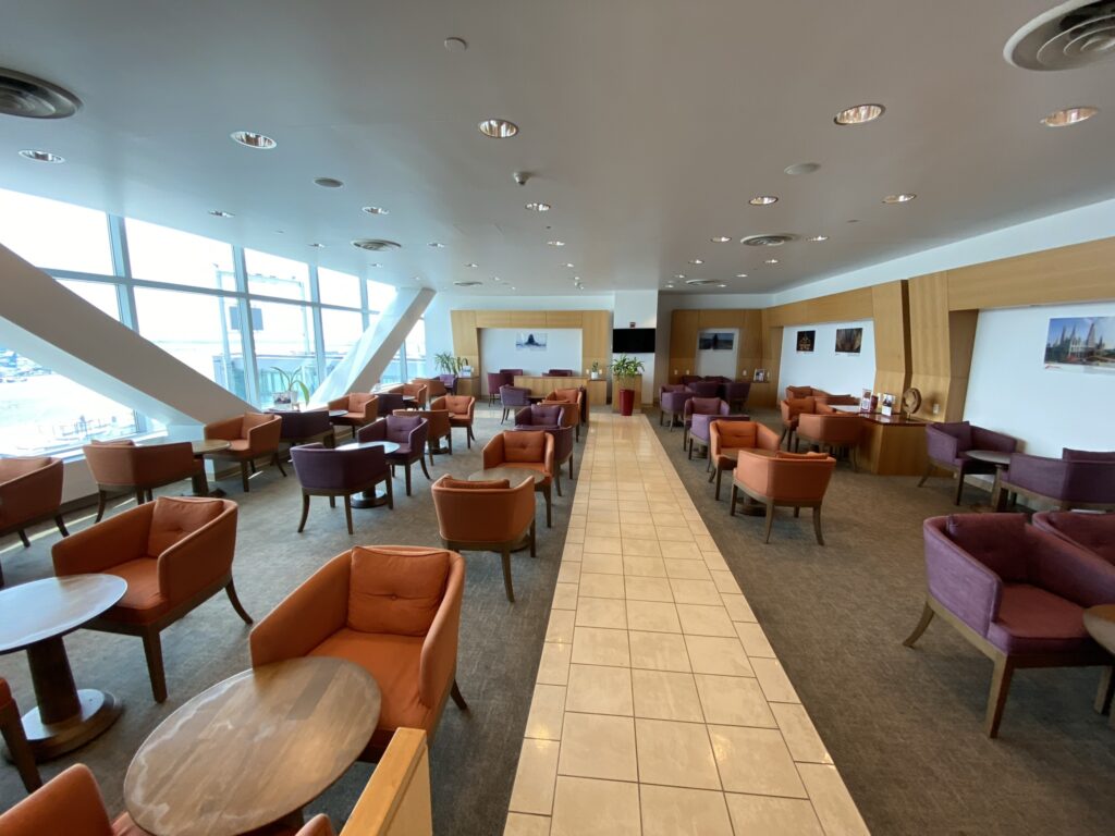 JFK Airport terminal 4 Air India Lounge with brown and purple chairs, and lots of light from the window