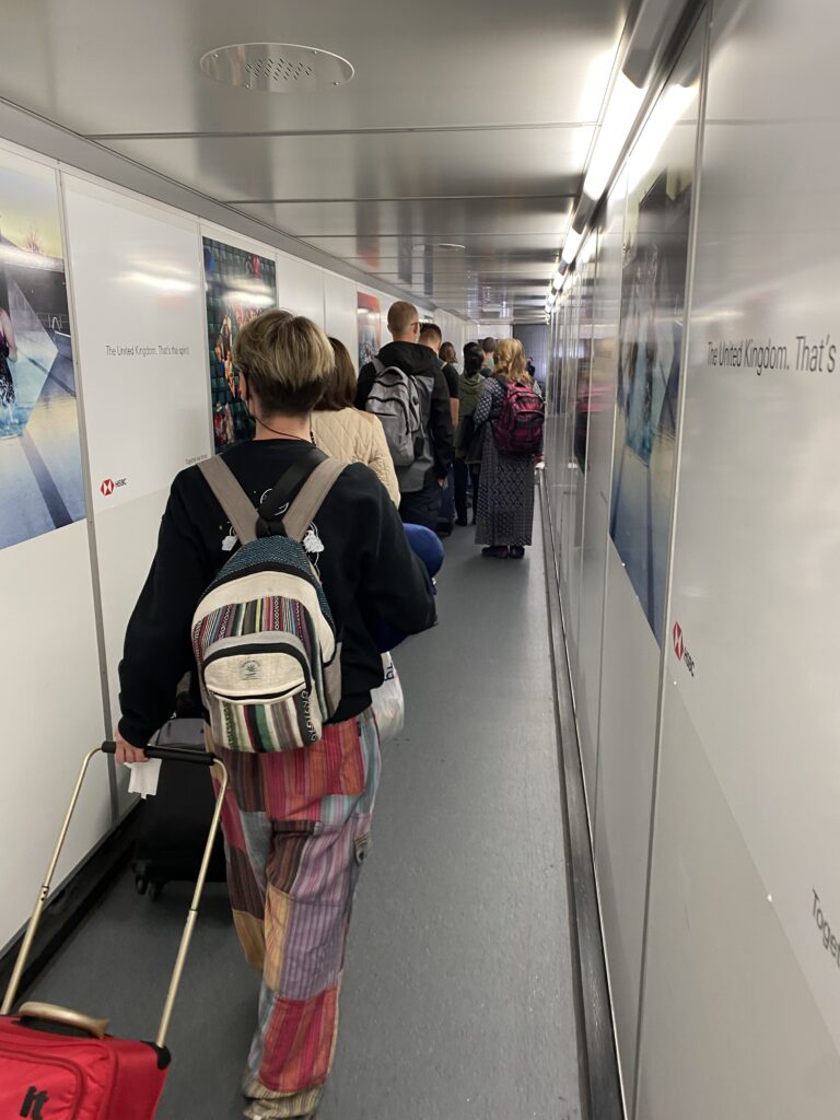 passengers lining up on the jet bridge for boarding.