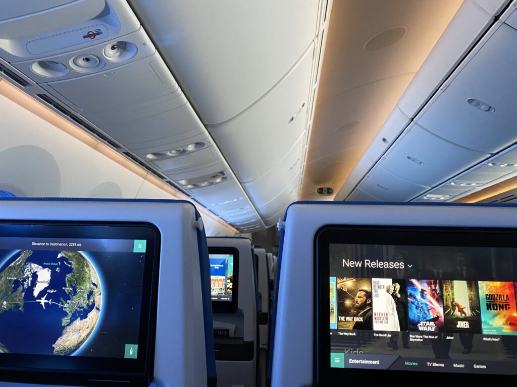 WestJet Economy class embedded IFE Screens. One showing movie selection and the other showing Flightpath 3D Moving map.