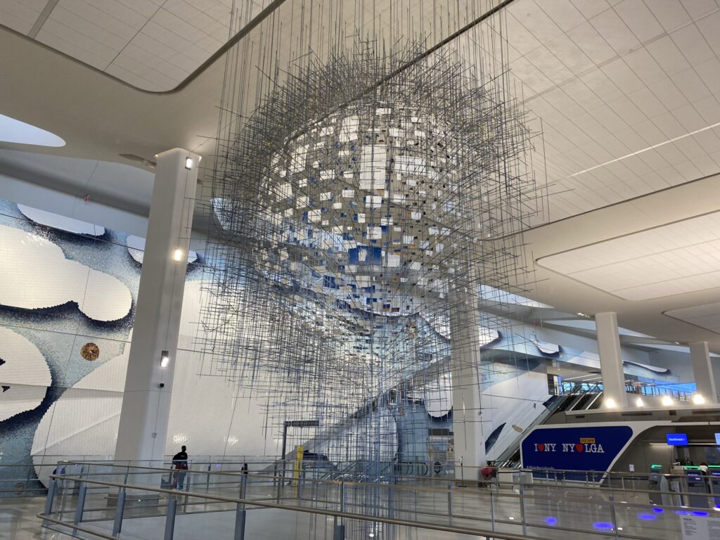 LaGuardia Terminal B's main departure hall. There is a large chandelier type art installation.