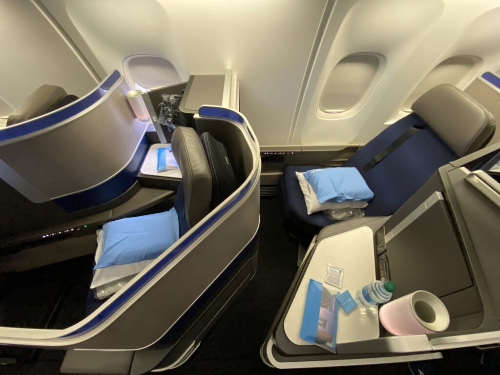 Up close photo of United Airlines' 767-300ER Polaris Business Class seat with the bedding, including cooling pillow, waiting for the passenger on the seat