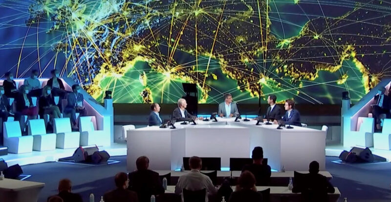 A screenshot of the Airbus summit with a large map of Europe seen behind a group of executives at a table