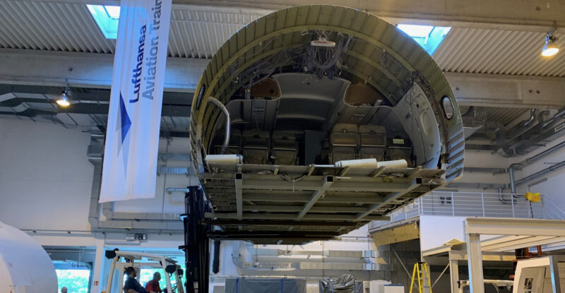 A forklift is carrying an aircraft cabin mockup