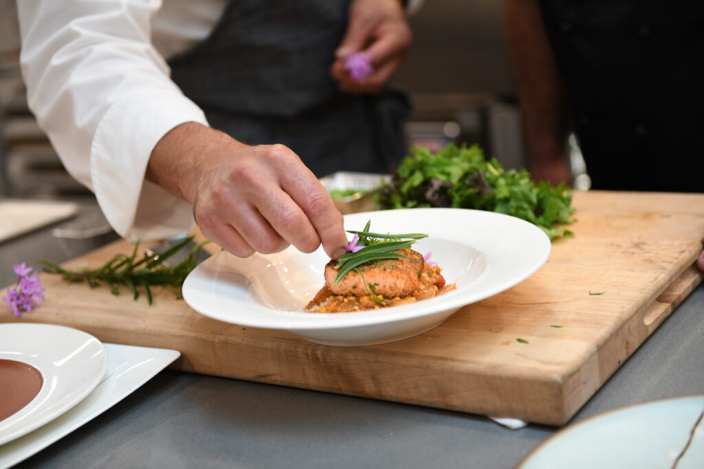 A chef tops off a dish 