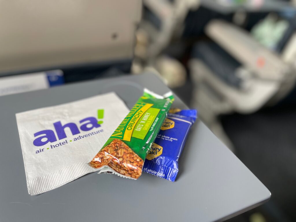 aha! airlines' snacks and napkin on a tray table