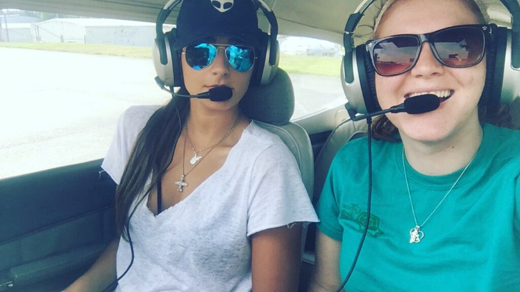 Caroline preparing to fly with her first passenger, friend Megan, who is seated beside her