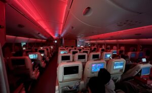 Emirates A380 cabin in economy class with red LED lighting.